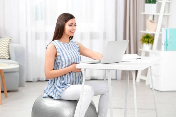 Mooie jonge zwangere vrouw thuis werken — Stockfoto