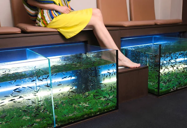 Una joven en el salón de belleza. Pedicura de pescado como nuevo tratamiento de spa moderno — Foto de Stock