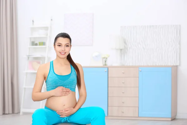 Giovane donna incinta formazione a casa. Concetto sanitario — Foto Stock