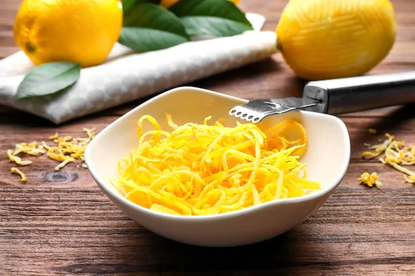 Cuenco con ralladura de limón y herramienta especial en la mesa —  Fotos de Stock