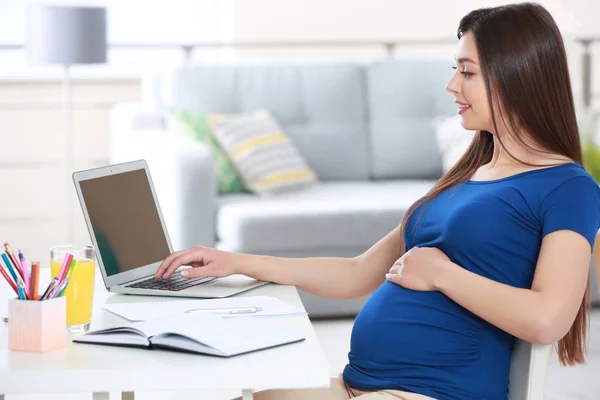 Vacker ung gravid kvinna som arbetar hemma — Stockfoto