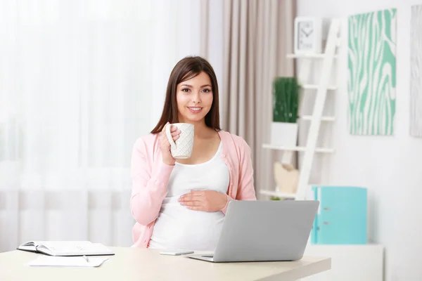 Mooie jonge zwangere vrouw thuis werken — Stockfoto