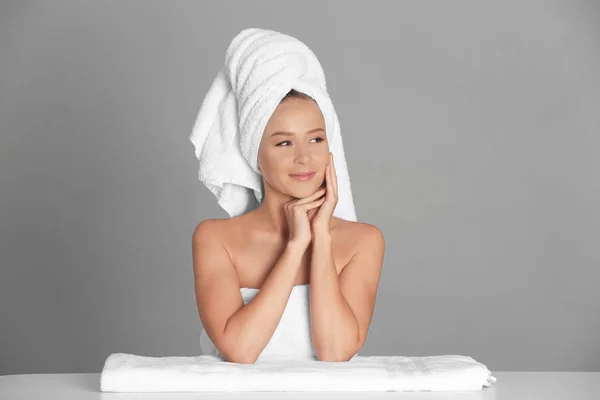 Hermosa mujer joven después del baño sobre fondo gris — Foto de Stock