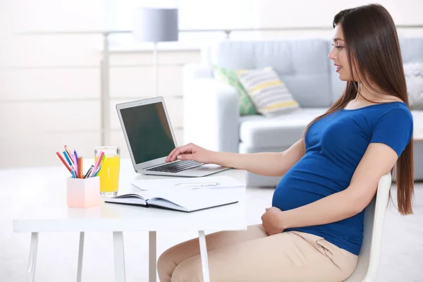 Belle jeune femme enceinte travaillant à la maison — Photo