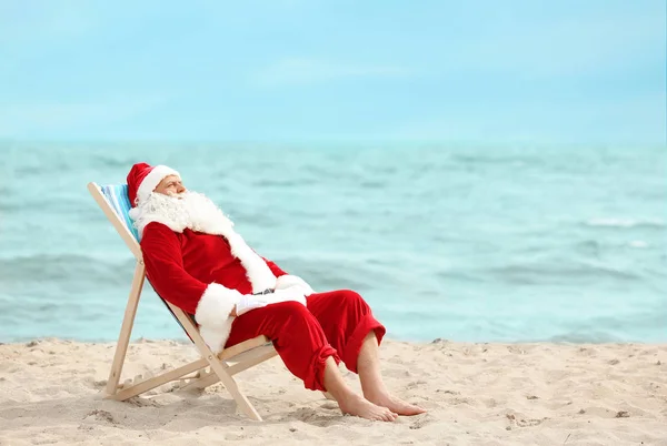 Authentieke Santa Claus ontspannen in ligstoel op het strand — Stockfoto