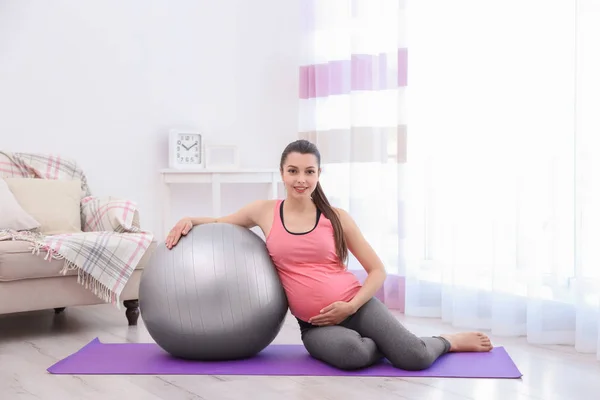 Jonge zwangere vrouw training thuis. Begrip gezondheid — Stockfoto