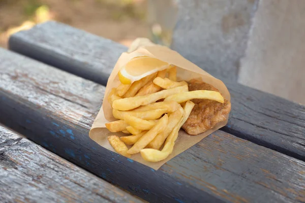 Limon dilimi bankta lezzetli kızarmış balık ve patates kızartması — Stok fotoğraf