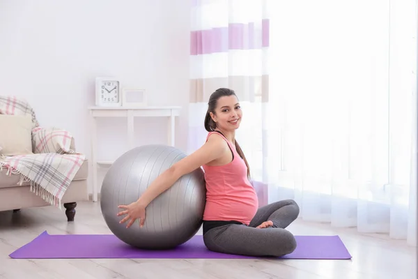 Jonge zwangere vrouw training thuis. Begrip gezondheid — Stockfoto