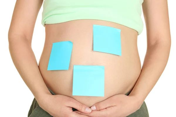 Беременная женщина с бумажными наклейками на животе, крупным планом. Концепция выбора имени ребенка — стоковое фото