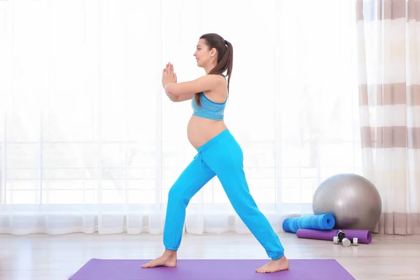 Mujer embarazada joven entrenando en el gimnasio. Concepto de salud —  Fotos de Stock