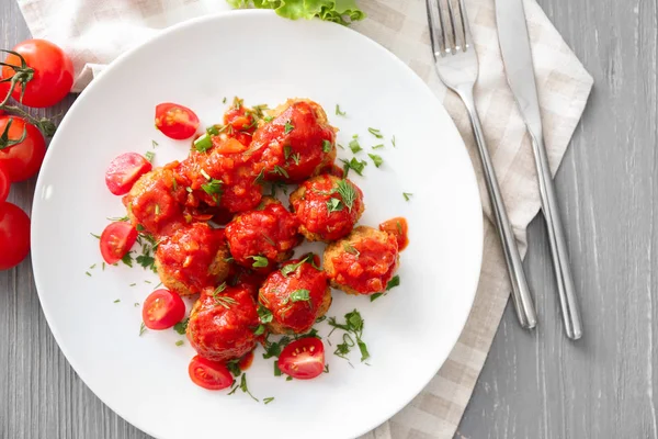 Plate with delicious turkey meatballs and tomato sauce on wooden table — Stock Photo, Image
