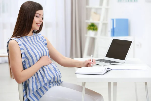 Belle jeune femme enceinte travaillant à la maison — Photo