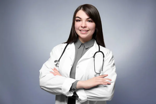 Jonge lachende dokter met gekruiste armen — Stockfoto