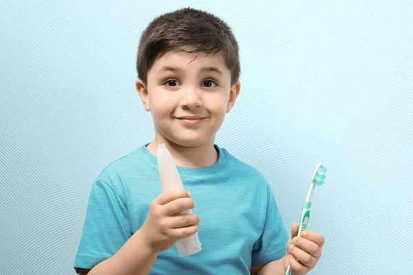 Netter Junge mit Zahnbürste und Paste auf farbigem Hintergrund. Konzept zur Zahnreinigung — Stockfoto