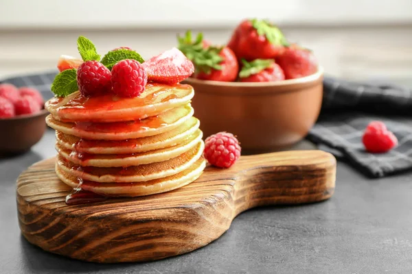 Pancake lezat dengan raspberry dan stroberi di papan kayu — Stok Foto