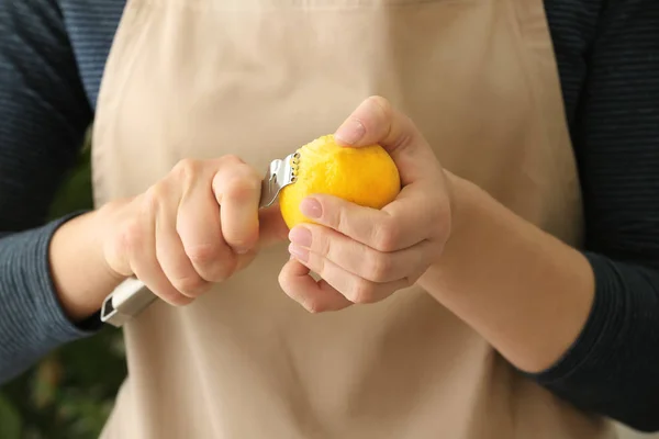 Femme décollant écorce de citron avec zester, gros plan — Photo