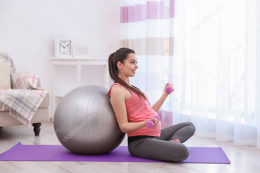 Young pregnant woman training at home. Health concept