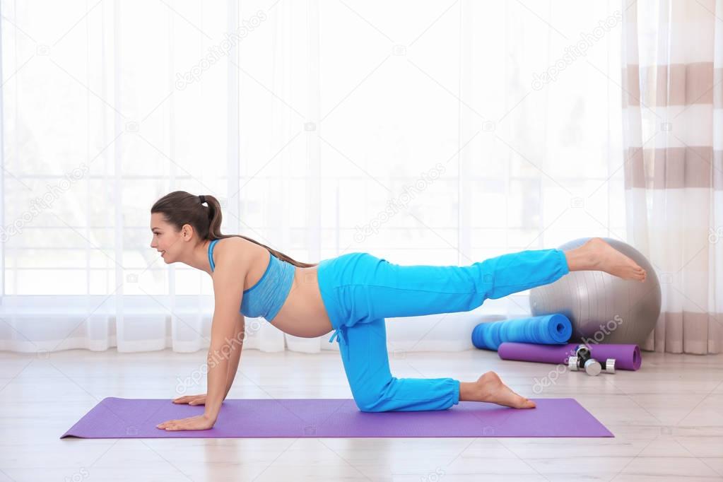 Young pregnant woman training in gym. Health concept