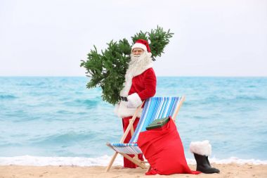 Otantik Noel Baba Noel ağacı ve çanta hediye plajda tam