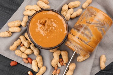 Lezzetli fıstık ezmesi ile kase, kavanoz ve fındık masada boş