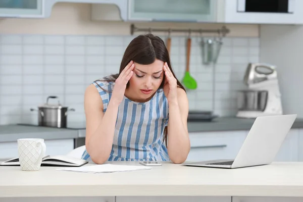 Mulher grávida bonita sofrendo de dor de cabeça enquanto trabalhava com laptop na cozinha — Fotografia de Stock