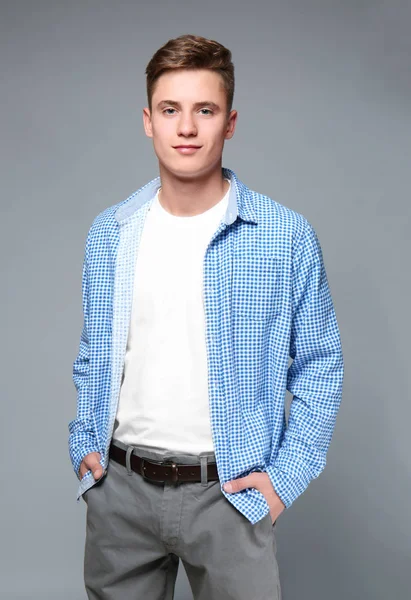 Jeune adolescent en chemise posant sur fond gris — Photo
