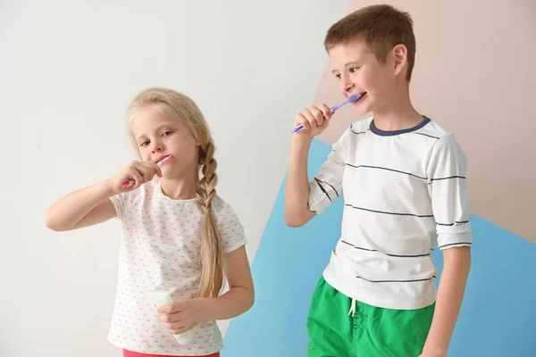 Petits enfants mignons nettoyer les dents sur fond de couleur — Photo
