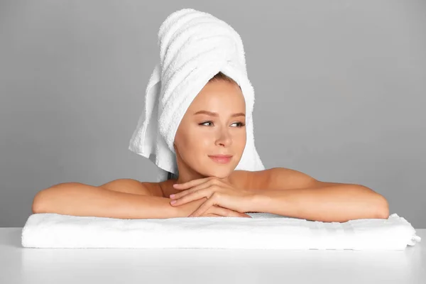 Hermosa mujer joven después del baño sobre fondo gris — Foto de Stock