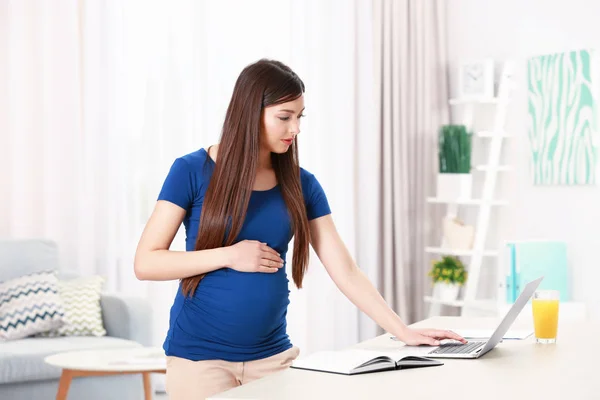 Beautiful young pregnant woman working at home — Stock Photo, Image