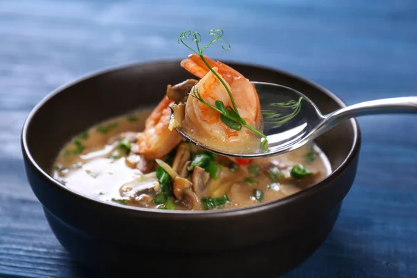 Lžíce s lahodné krevety a polévka v misce na stole — Stock fotografie