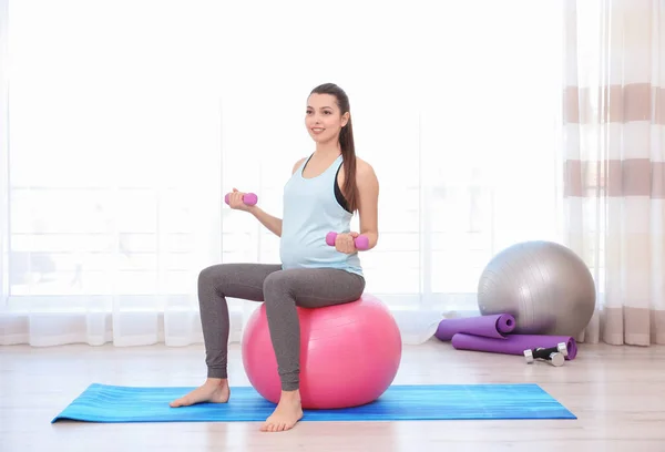 Молодая беременная женщина тренируется в спортзале. Концепция здоровья — стоковое фото