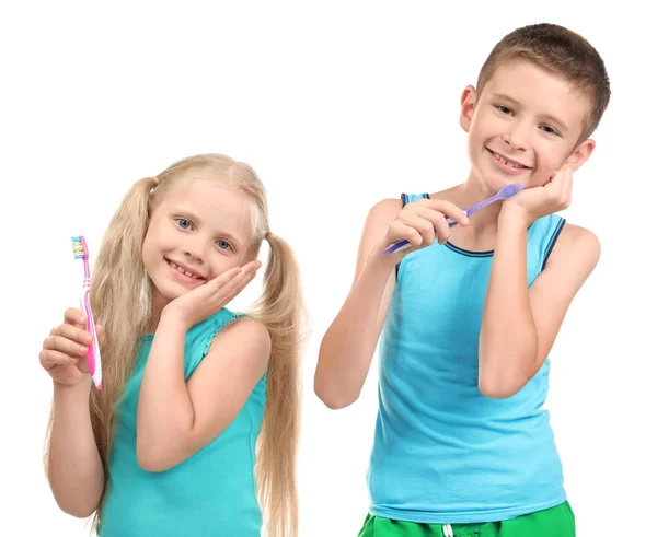 Lindos niños pequeños con cepillos de dientes sobre fondo blanco. Concepto de limpieza dental — Foto de Stock