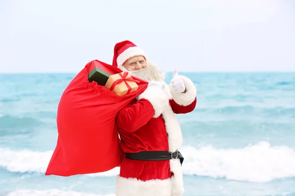 Papai Noel autêntico com grande saco vermelho cheio de presentes no fundo do mar — Fotografia de Stock