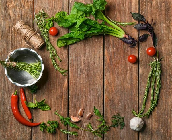 Composition avec des herbes et légumes frais sur fond de bois — Photo