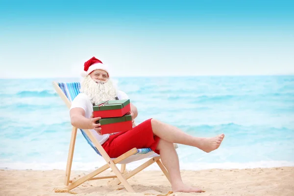 Autentyczny Święty Mikołaj z darem pól w leżak na plaży — Zdjęcie stockowe