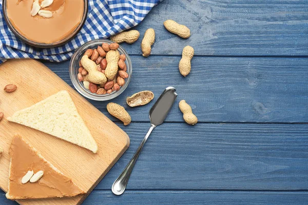 Composición con tostadas y deliciosa mantequilla de maní sobre mesa de madera —  Fotos de Stock