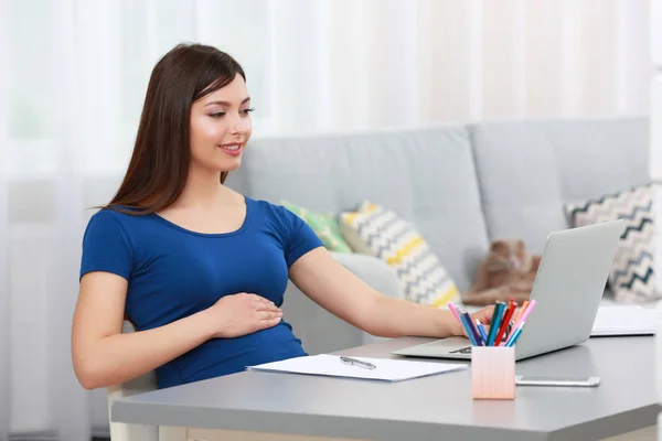 Mooie jonge zwangere vrouw thuis werken — Stockfoto