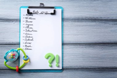 Pano ile bebek isimleri ve rattle ahşap arka plan üzerinde listesi