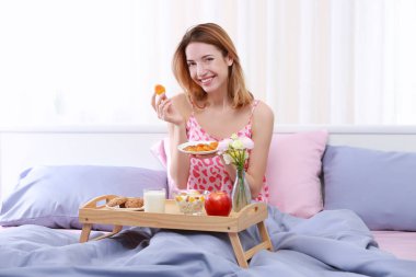 Genç bayan kahvaltı yapıyor.