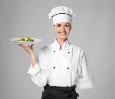 Genç kadın Şef salata ile plaka üzerinde açık renkli holding