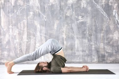 Yoga yapan genç adam. 