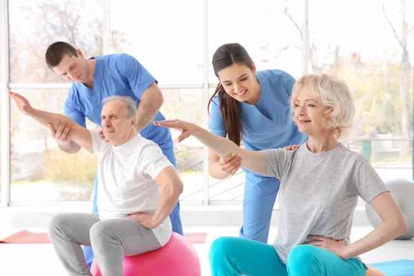 Physiotherapeuten arbeiten mit älteren Patienten in moderner Klinik — Stockfoto