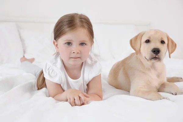 Söta barn med Labrador Retriever på säng — Stockfoto