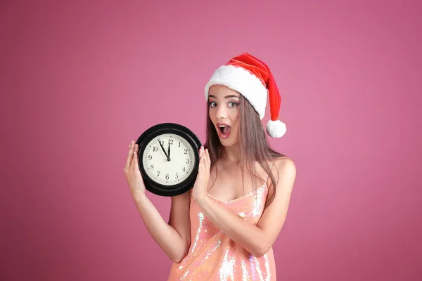 Mujer joven en Santa sombrero con reloj —  Fotos de Stock