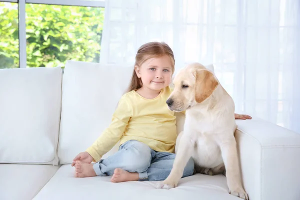 Lindo niño con Labrador Retriever en el sofá —  Fotos de Stock