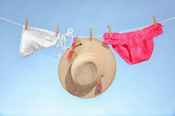 Stroje plażowe kapelusz i okulary przeciwsłoneczne, wiszące na lina — Zdjęcie stockowe
