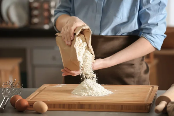 Koch gießt Mehl auf Holzbrett — Stockfoto