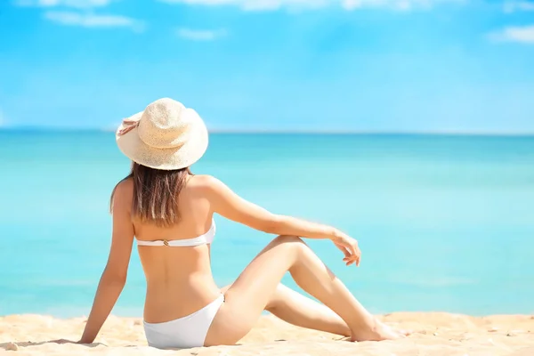 Mooie jonge vrouw in bikini op strand — Stockfoto