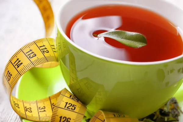Xícara com chá e fita métrica na mesa — Fotografia de Stock