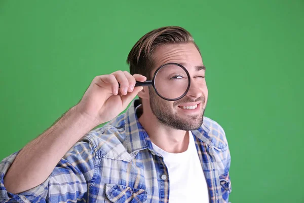 Handsome young man with magnifier — Stock Photo, Image